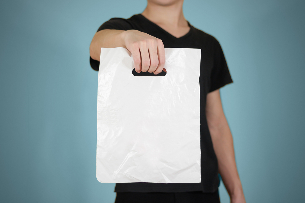 Mężczyzna trzymający białą torebkę foliową - niupak.eu
