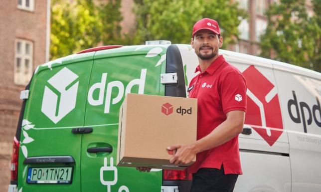 Uśmiechnięty kurier DPD trzyma paczkę przy elektrycznym samochodzie dostawczym, symbolizując zaangażowanie firmy w elektromobilność i zrównoważony rozwój.