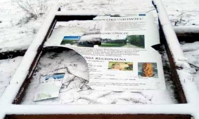 Tablica informacyjna zniszczona Okuniowiec gmina Suwałki